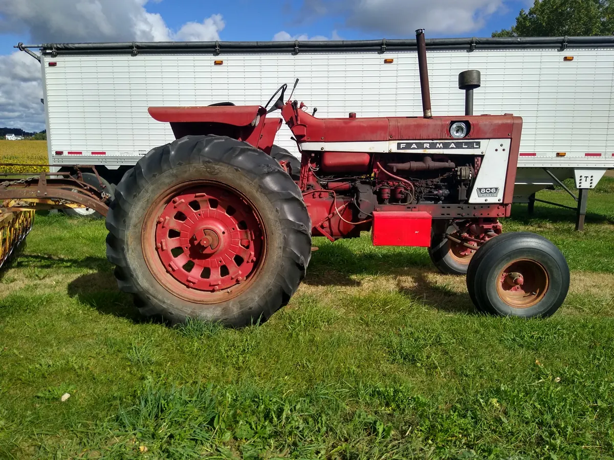 Vintage Farmall tractor and grain trailer documented during a farm equipment appraisal