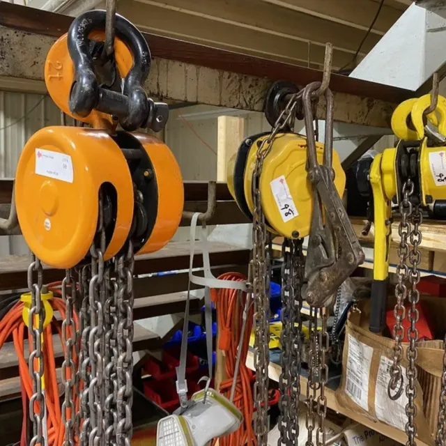 Manual chain hoists and a lever hoist hanging on a rack